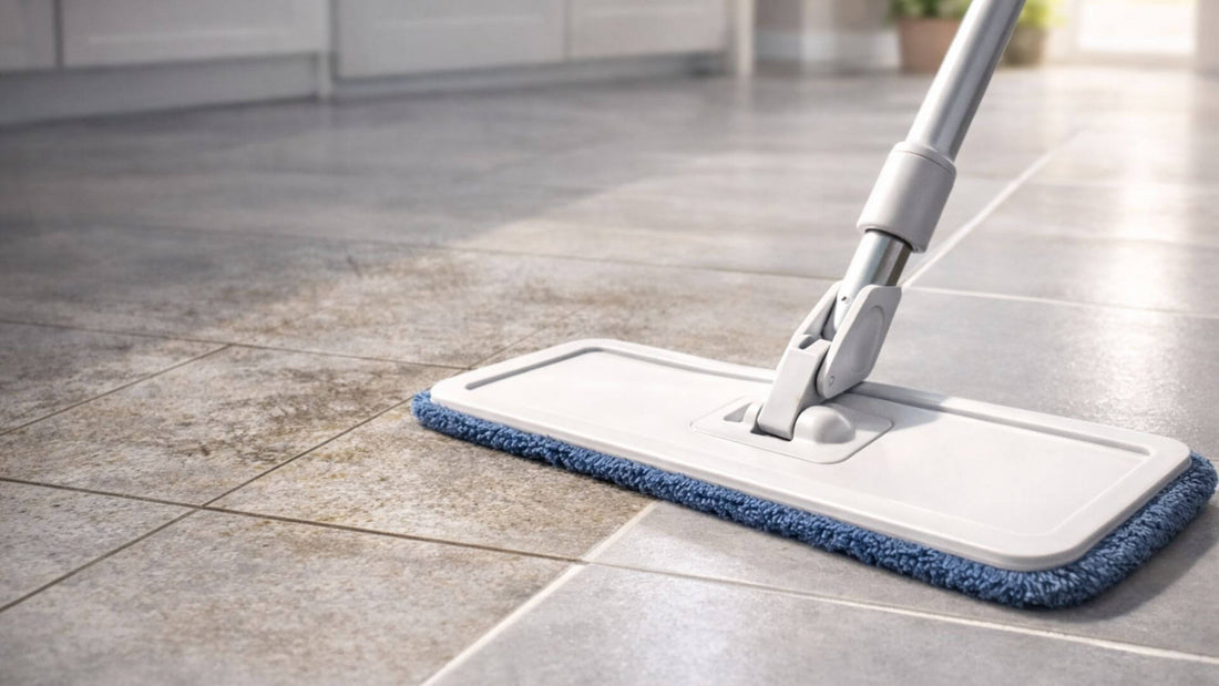 Serpillère microfibre nettoyant un sol en carrelage avec une zone sale et une zone propre dans une cuisine lumineuse