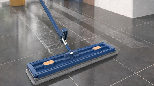 Serpillère plate microfibre nettoyant une grande surface en carrelage dans un intérieur moderne avec traces d’eau visibles