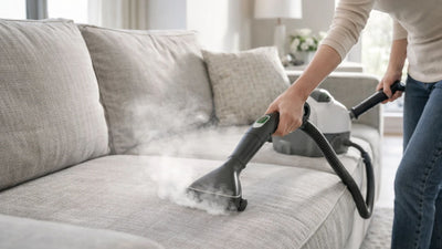 Nettoyeur vapeur pour canapé en action, nettoyage de taches sur tissu d’ameublement dans salon moderne