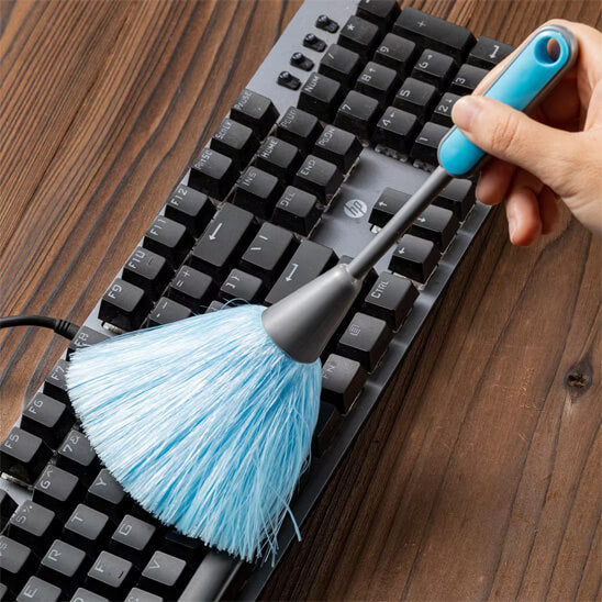 plumeau bleu nettoie clavier noir ordinateur